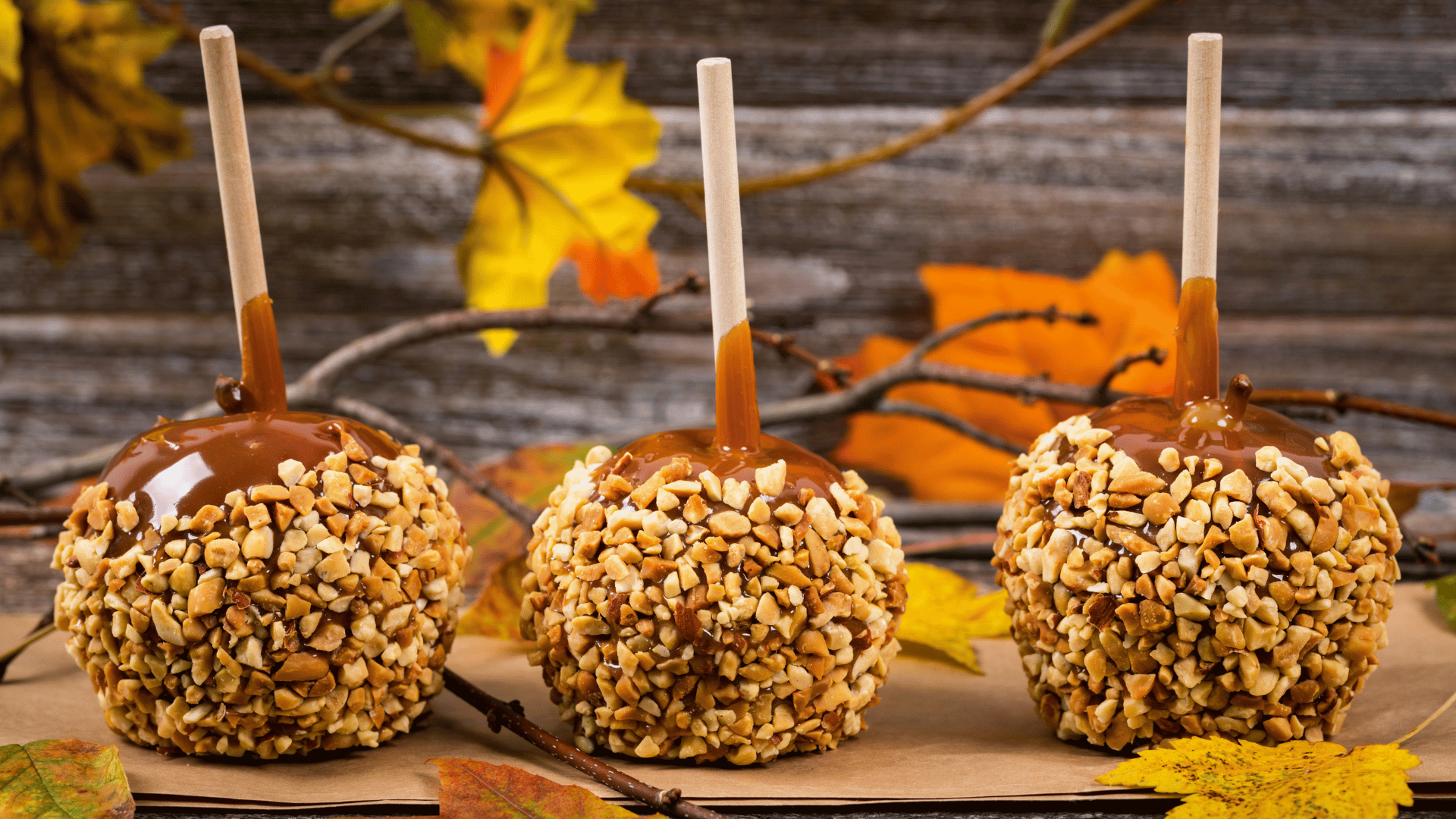 Caramel apples, popcorn balls, and ghost cookies displayed on a Halloween table with Recipe Memory